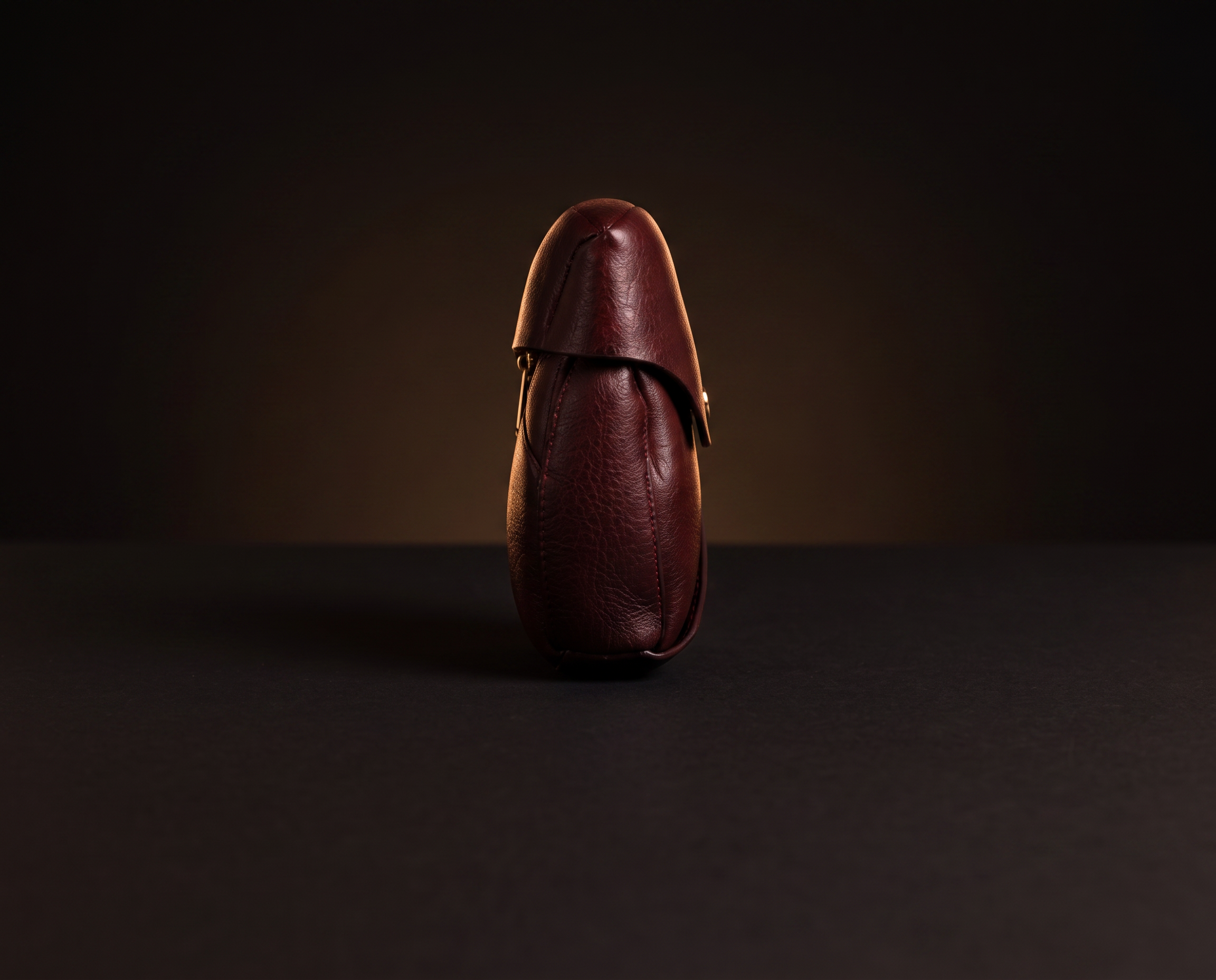 The Roos petal clutch in profile, showing its slim 5.5 cm depth and softly rounded ends