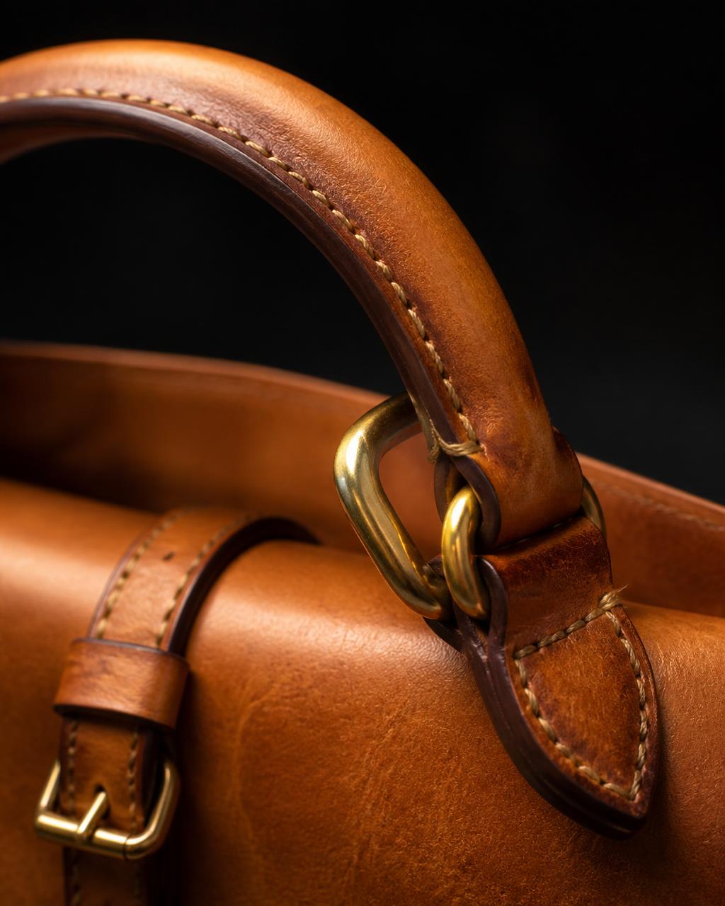 Nandi handle detail — gold ring and hand saddle-stitching
